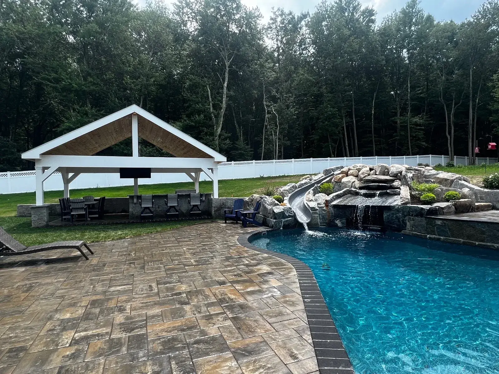 A custom paver patio and pool waterfall created by a top landscaper & hardscaper in Sharon, CT.